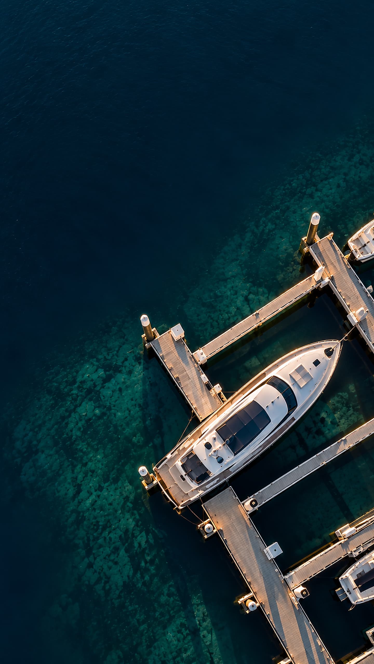 Aerial view of a motor yacht in its slip at a marina, dark water to the left